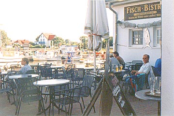Restaurante Fisch-Bistro en Vitte, isla de Hiddensee en el Báltico: la terraza con vista al puerto